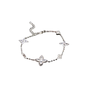 Silver plated floral bracelet with zircon clover charms on a white background