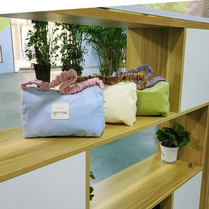 Detailed view of corduroy handbags in pastel colors with contrasting pleated handles