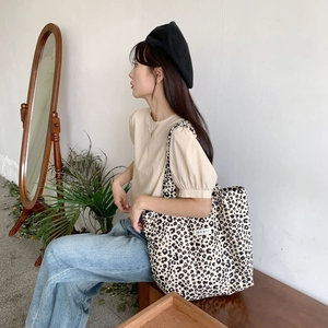Lifestyle shot of large leopard print canvas tote bag paired with vintage outfit