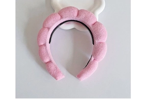 Detailed view of pink plush cloud headband with internal non-slip black hair comb teeth