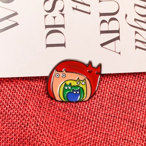 Rainbow cat enamel brooch with colorful nested kitten design on red woven background