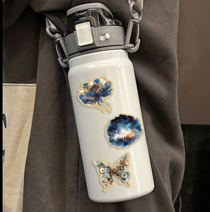 Autocollants univers cartoon étanches sur une bouteille avec motifs fleurs et papillons