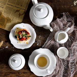 European style white ceramic teapot set with teapot, teacups and saucers on a wooden table