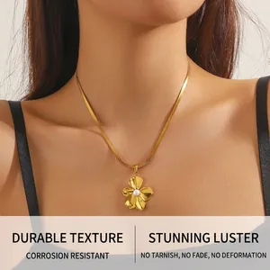 Vue détaillée d'un pendentif fleur dorée avec perle sur une chaîne serpent élégante