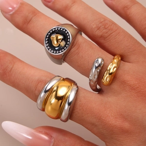 Three mixed metal rings including a black enamel sacred heart and textured gold open band