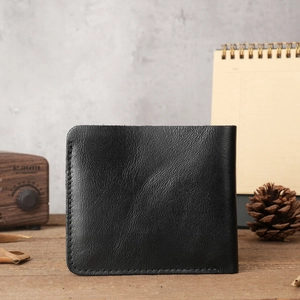 Detailed view of black genuine crazy horse leather wallet on a vintage wooden surface