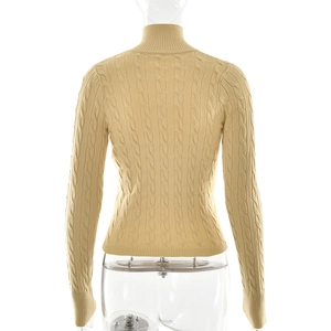 Vue détaillée du dos d'un pull en maille beige avec motifs de torsades classiques