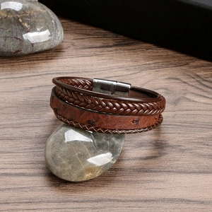 Detail of a brown multi-layer braided leather bracelet for men with a silver magnetic clasp