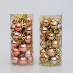 Detail of pink and champagne gold mini Christmas tree ornaments in clear tube packaging