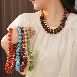 Détail de colliers de perles colorés style vintage sur mannequin et tenus à la main