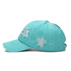 Detail of washed teal baseball cap featuring silver glitter stars and distressed fabric
