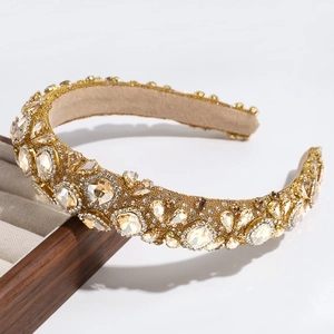 Detailed view of luxury gold headband with champagne crystals and rhinestones on a tray