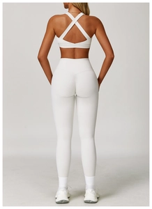 Dettaglio del set yoga bianco con reggiseno incrociato e leggings a vita alta