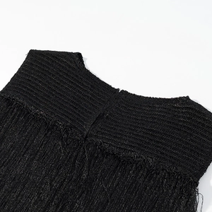Vue détaillée d'un haut noir sans manches en maille avec des franges élégantes