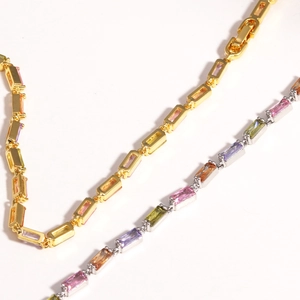 Dettaglio di bracciali in oro 18K e argento con zirconi cubici colorati incastonati