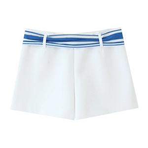 Detail of high-waisted white shorts featuring a blue striped fabric belt for women