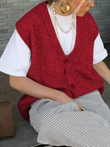 Inquadratura esterna di gilet casual in maglia rossa con bottoni, t-shirt bianca e pantaloni