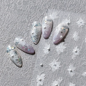3D white floral nail stickers with embossed pearls and glitter on lavender nails