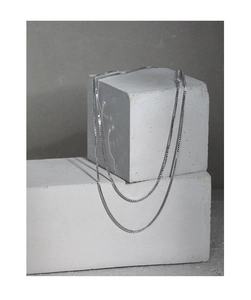 Detailansicht der S925 Sterling Silber Box-Kette auf minimalistischen Betonblöcken