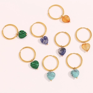 Detail of golden hoop earrings featuring various heart-shaped natural stone pendants