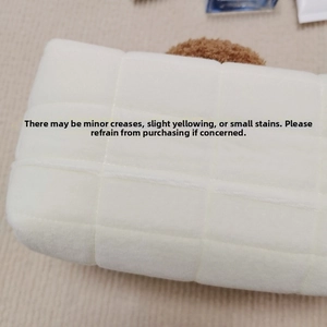 Close-up of white quilted plush pencil case with soft texture and square pattern