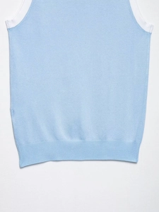 Gros plan du gilet en maille bleu clair avec bordure blanche et ourlet côtelé