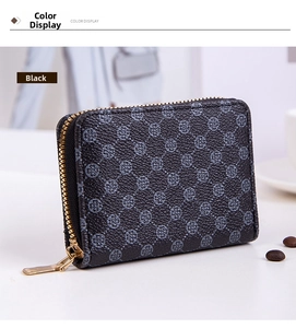 Detail of black leather mini wallet featuring clover print and golden zipper