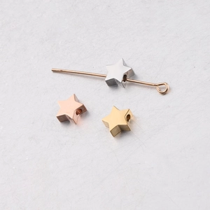 Detailed close-up of star-shaped metal beads in gold, rose gold, and silver finishes