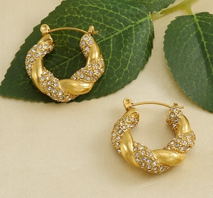 Detailed close-up of 18K gold-plated twisted hoop earrings with sparkling crystal pavé