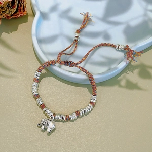 Detail of hand-woven ethnic bracelet with silver elephant charm and colorful beads