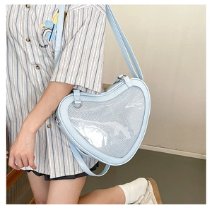 Model wearing a light blue heart-shaped JK ita bag with clear window and adjustable strap