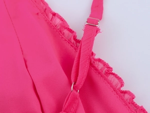 Détail de la robe rose avec bretelles réglables, boucles en métal et bordure dentelle