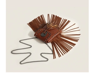 Close-up of brown fringe crossbody bag with metal rivets and a slim chain strap