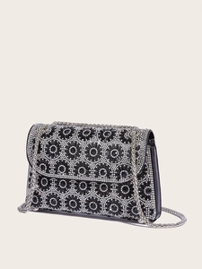 Close-up of sparkling black rhinestone flower patterns and silver chain strap on bag