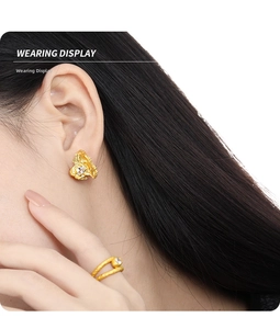 Wearing display of asymmetric gold earrings and open ring set with zircon details