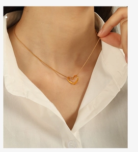 Vue détaillée d'un collier pendentif cœur en or 18 carats porté sur le cou
