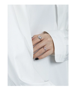Close-up of pink heart-shaped zircon inlay on minimalist silver open rings