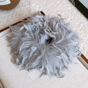 Vue détaillée du chouchou élégant en plumes grises avec une texture douce et plumeuse