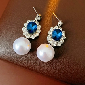 Orecchini vintage in argento con cristallo blu, strass e perle bianche su pelle