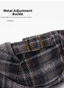 Detail of the vintage plaid cap featuring an adjustable bronze metal buckle and tweed texture