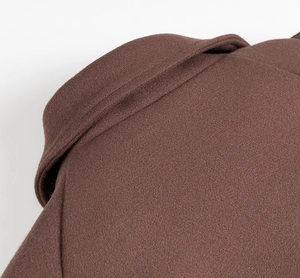 Détail du col à revers en laine de qualité marron caramel avec couture fine