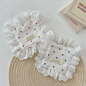 Detail of square cotton coasters with exquisite lace edges and embroidered hearts