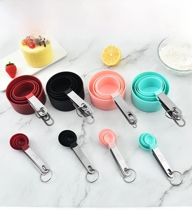 Detail of colorful measuring spoons set with stainless steel handles on marble surface