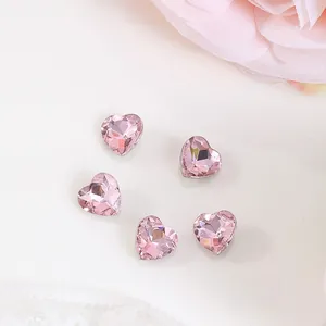 Detailed macro view of 8x8mm heart-shaped pink crystal nail art charm with silver border