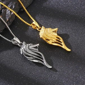 Detail of Viking wolf head pendants in gold and silver steel on a black textured surface