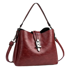 Retro burgundy faux leather bucket bag with metallic clasp for elegant women's crossbody wear