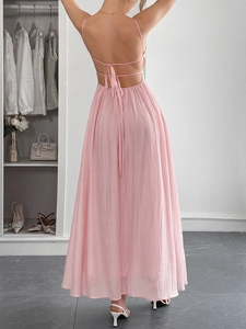 Detailed back view of a pink backless maxi dress with cross-tie straps and pleated texture
