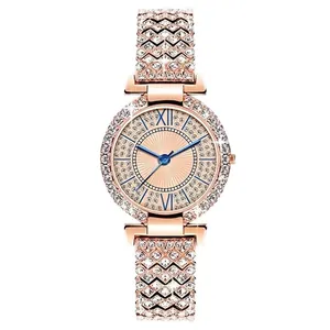 Dettaglio dell'orologio in oro rosa con lancette blu e castone di cristalli lucenti