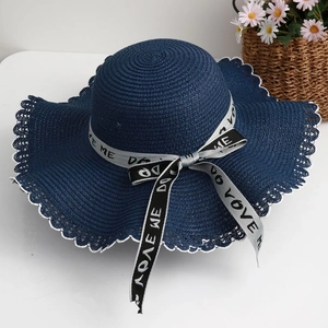 Detail of blue straw hat featuring white scalloped edges and bow ribbon decoration