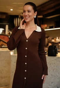 Détail d'une robe en tricot marron foncé avec col polo blanc et boutons en perles
